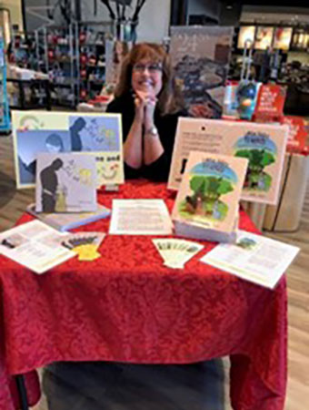 Une femme assise à une table remplie de livres.