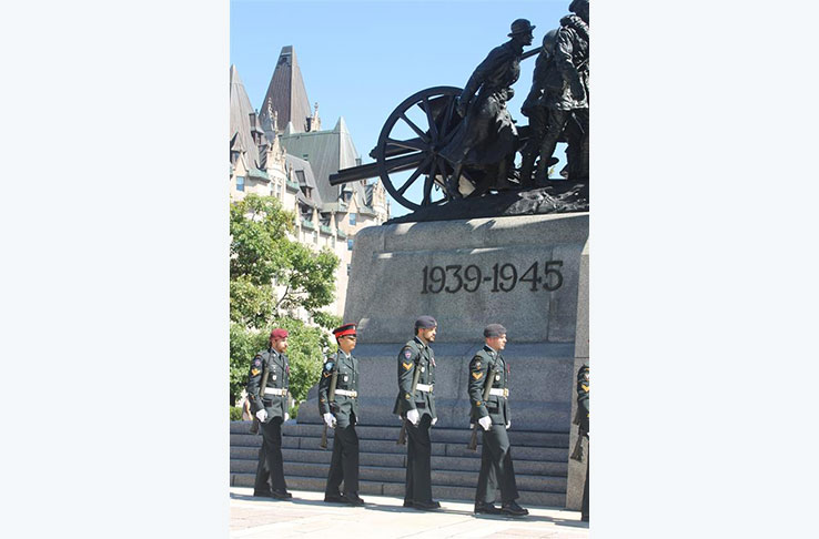 Un groupe de soldats debout à côté d'un monument
