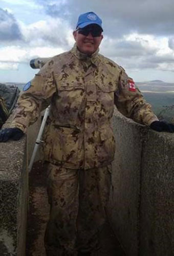 un homme portant un uniforme militaire et souriant