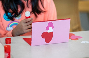 A group of four young students holding homemade valentines. 