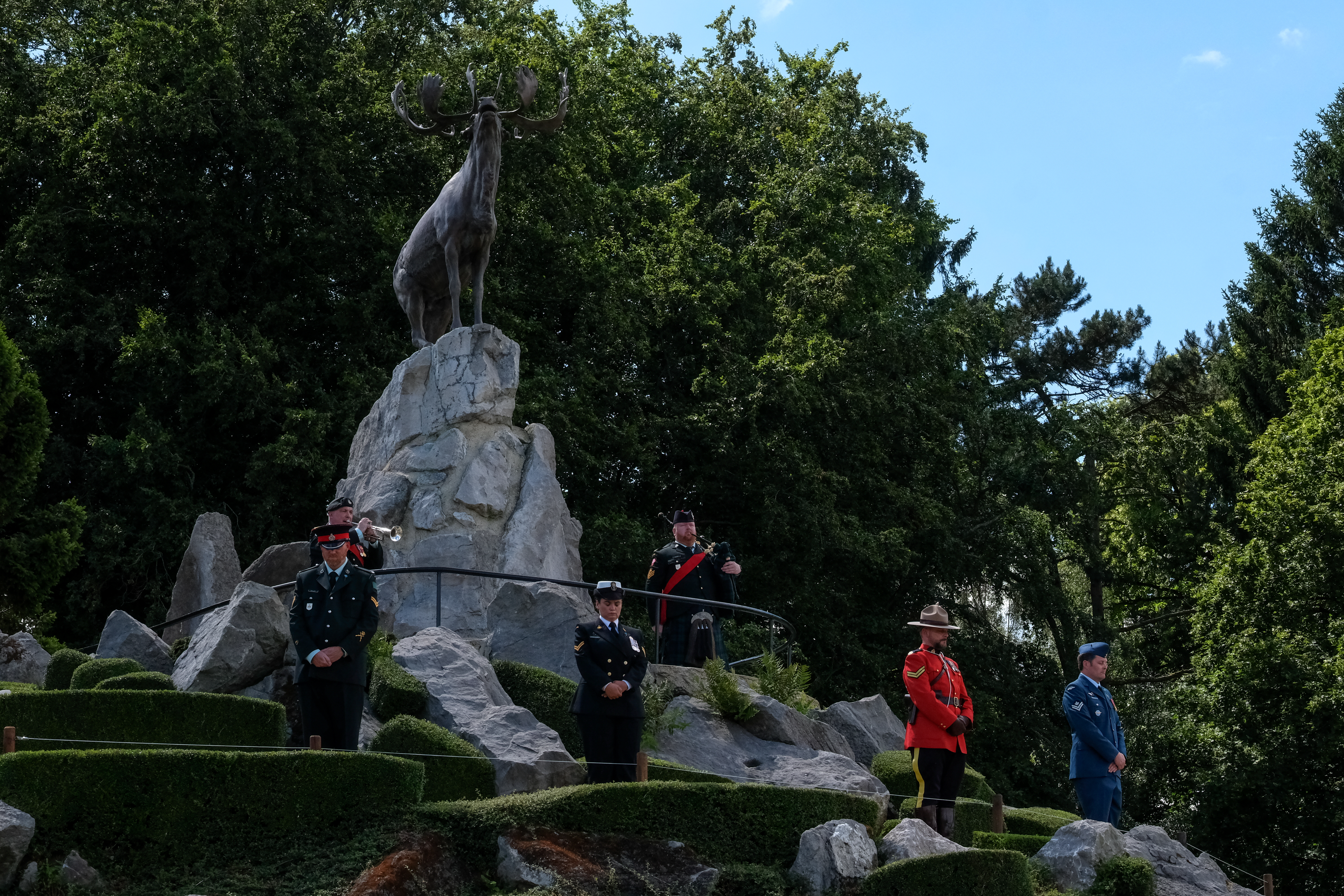 A memorial featuring a caribou statue on a large stone pedestal.