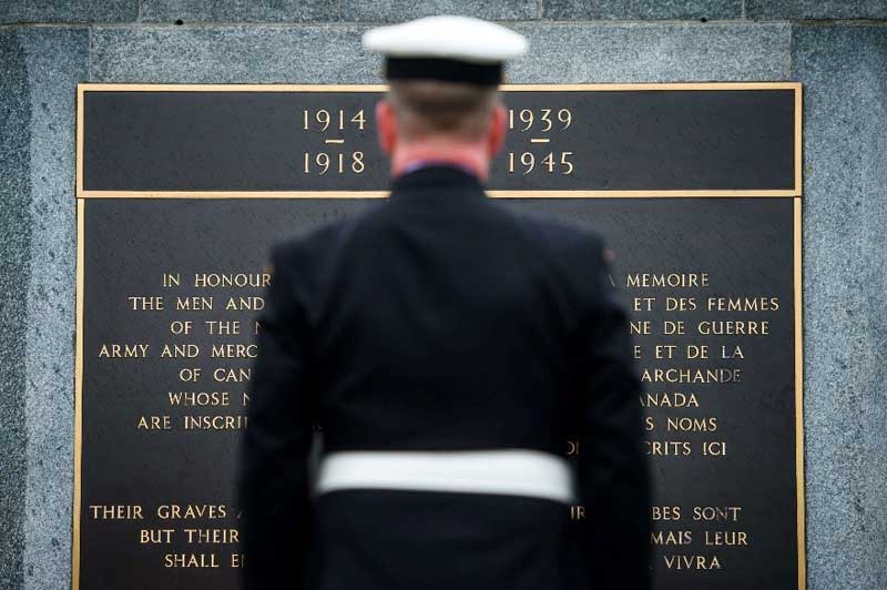 An image of a soldier in front of a memorial.