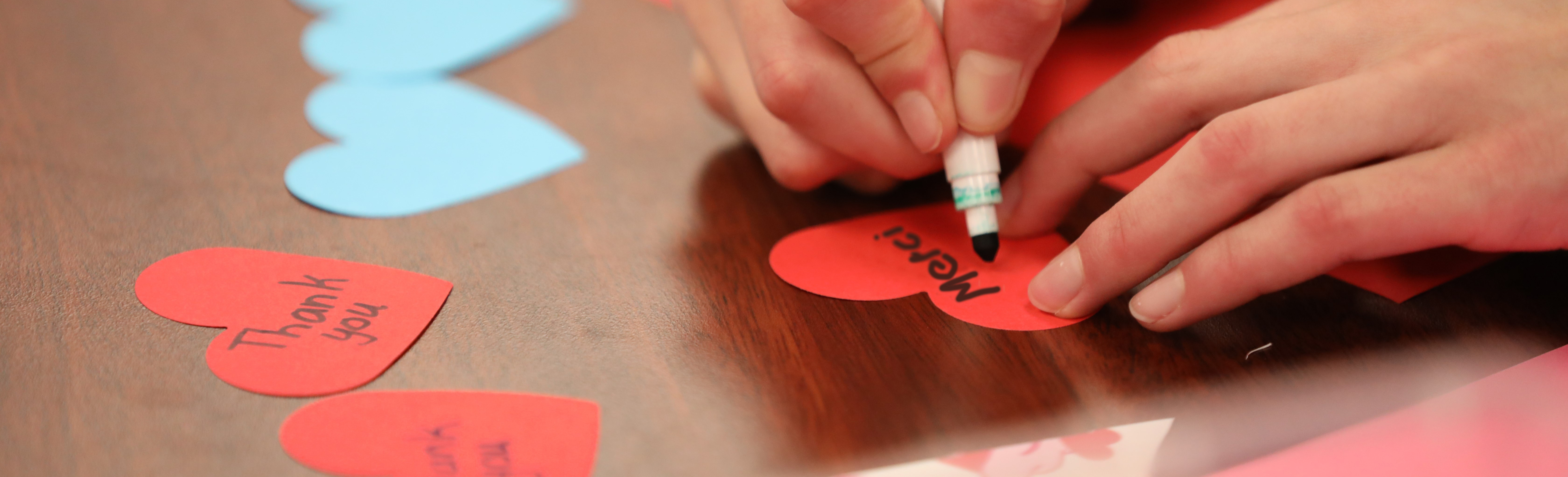 Image d’archive d’une personne écrivant sur une carte de Saint-Valentin en forme de cœur<br />