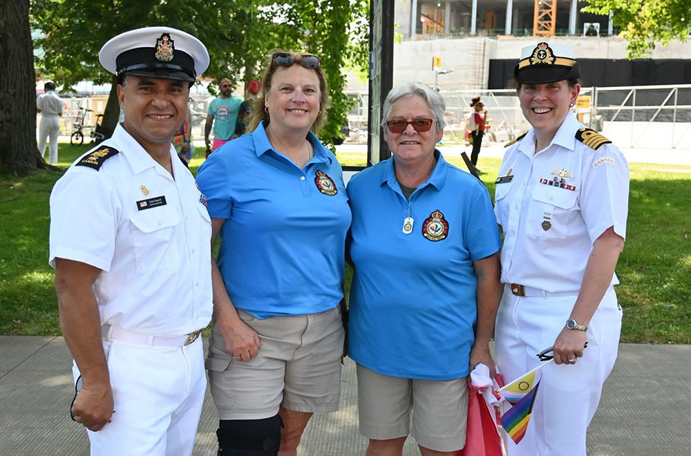 Sherry Lundrigan standing with a group of people. Some of them are wearing Navy uniforms.