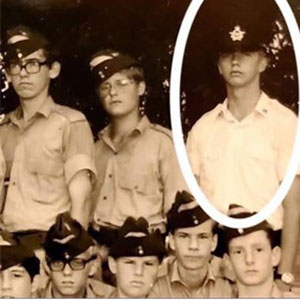 A young Steven Deschamps poses with cadets dressed in uniform. Steven is wearing a peaked cap while the other young men are wearing wedge caps. 
