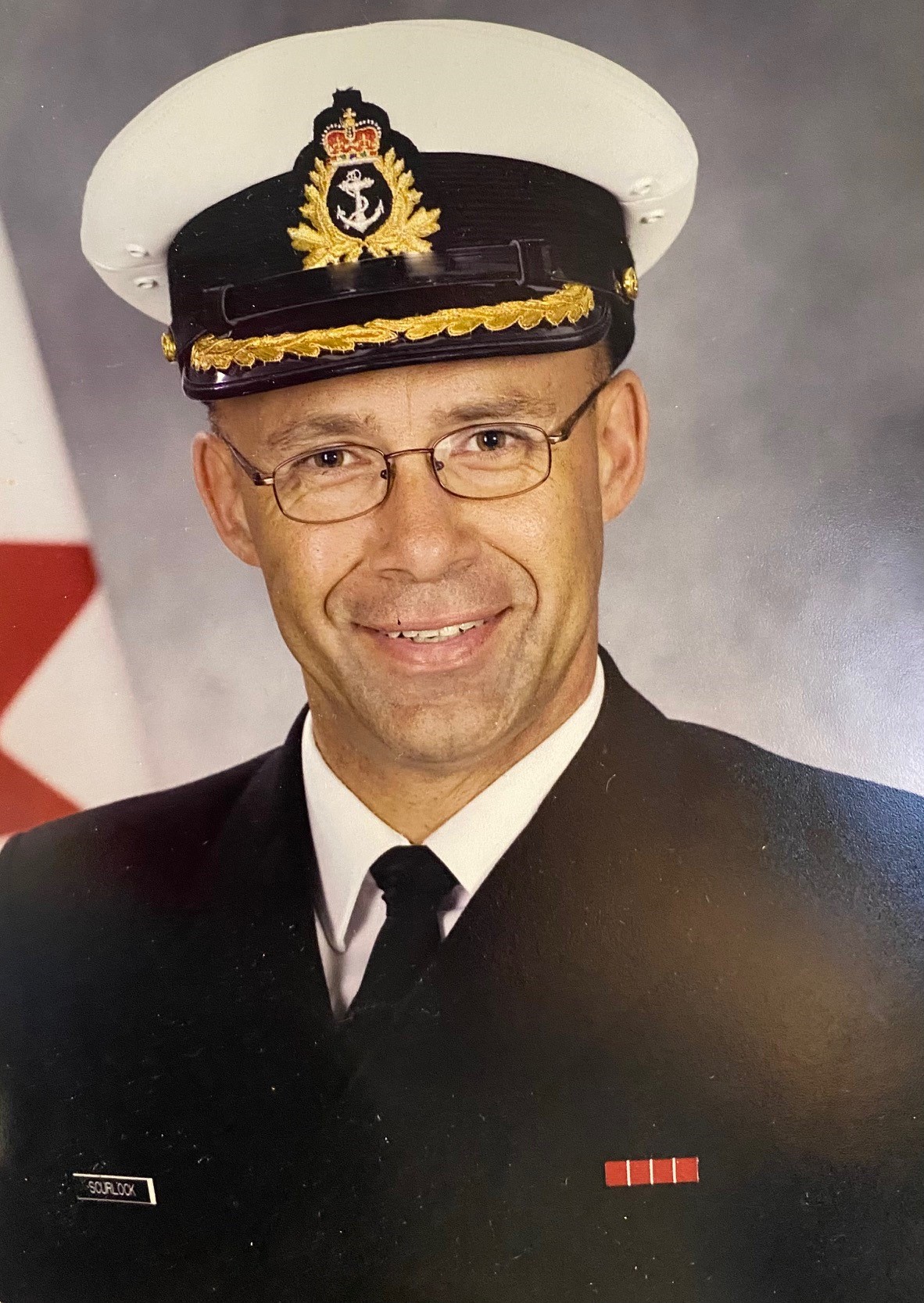 Portrait officiel de Treena Scurlock portant l’uniforme noir de la Marine et affichant un sourire.